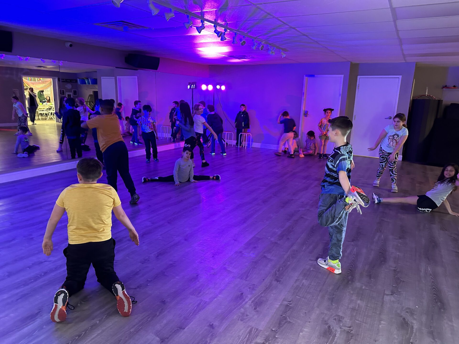 IMG_0713 A diverse group of children and adults performing on stage at a school event.